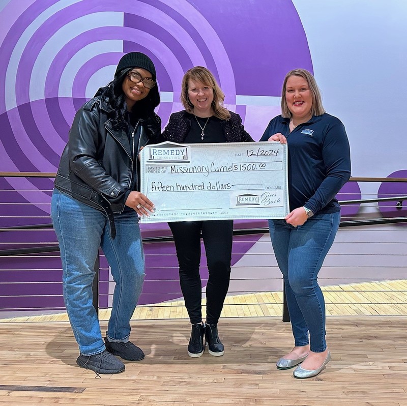 Karen Lowerr of Remedy Consulting presenting check to Jessica Currie and Kristen Mekemson of Missionary Currie 4 Women and Children in Milwaukee, WI in December 2024.