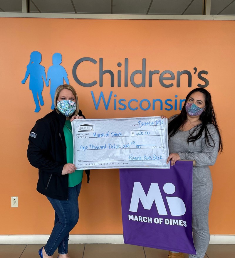 Karen Lowerr of Remedy Consulting presenting check to March of Dimes Wisconsin representative Alma Velez in New Berlin, Wisconsin.